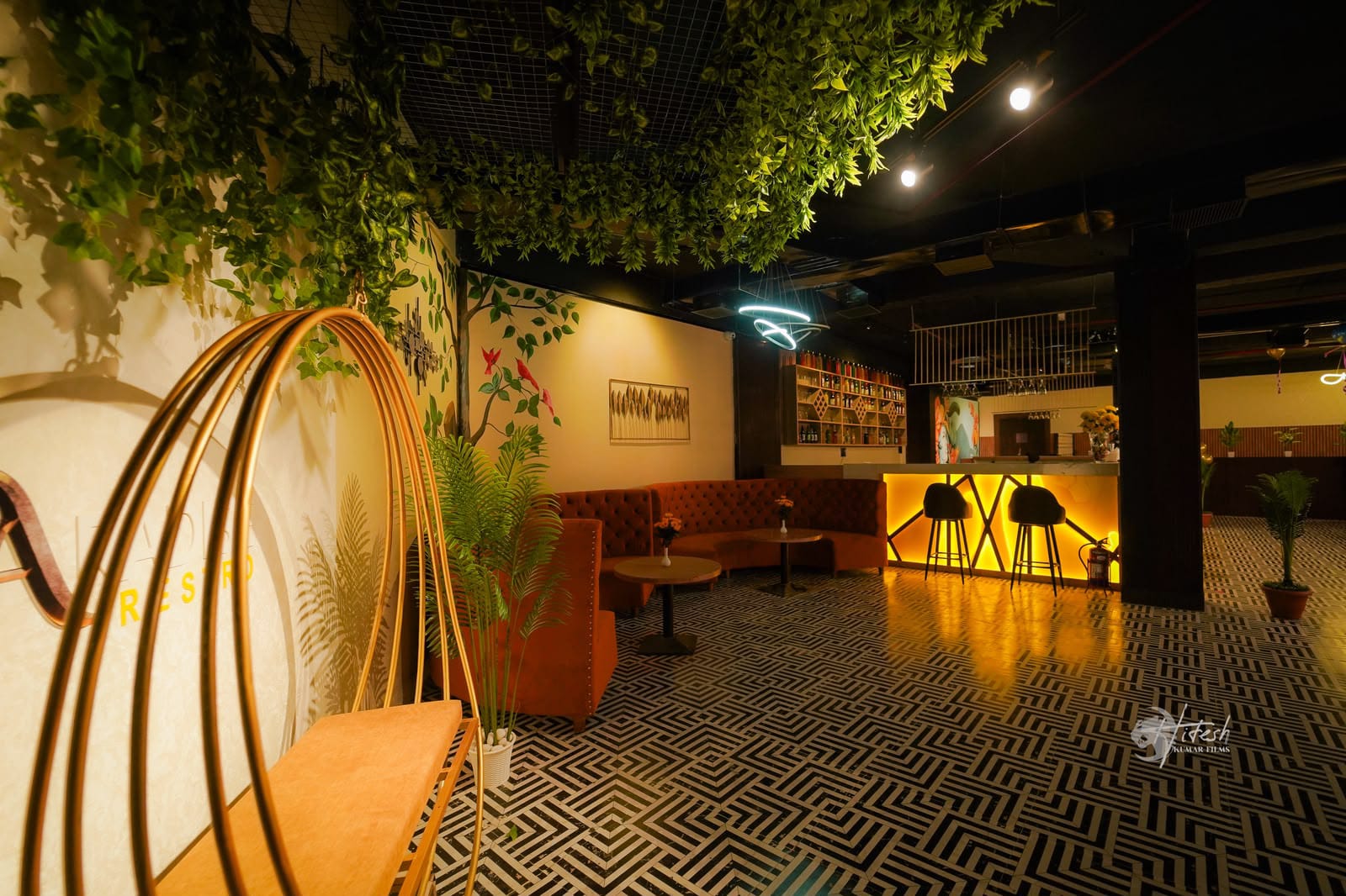 Paradise Restro lounge with geometric floor pattern, golden bar counter and swing chair